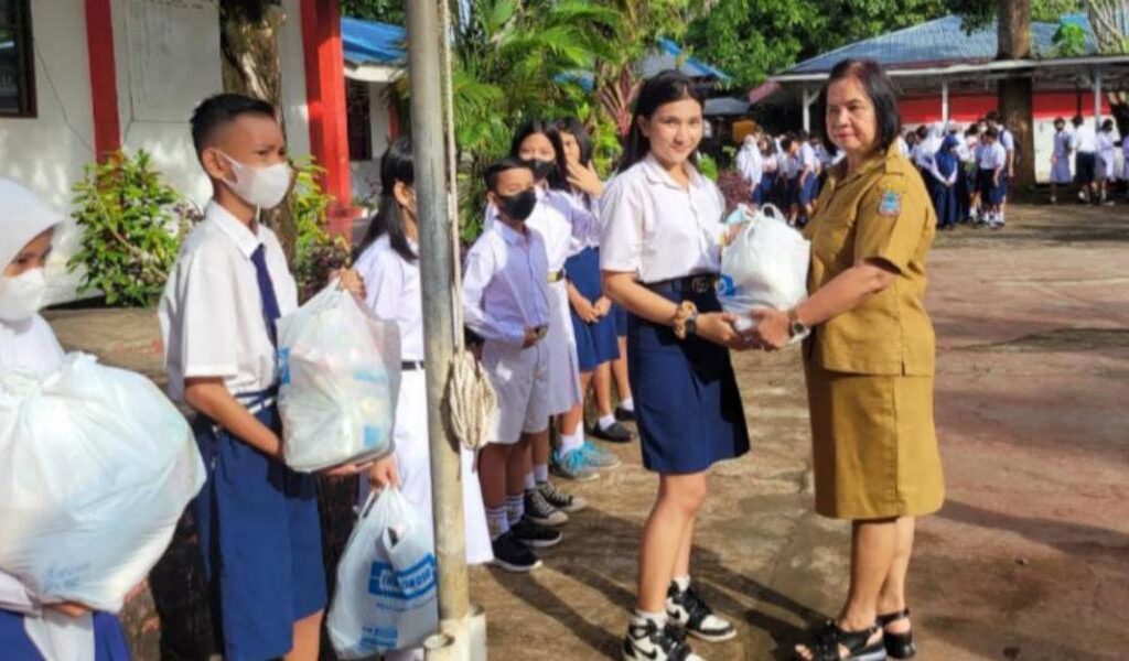 Kepala SMP Negeri 7 Manado Syenny Waworuntu saat membagikan Sembako.